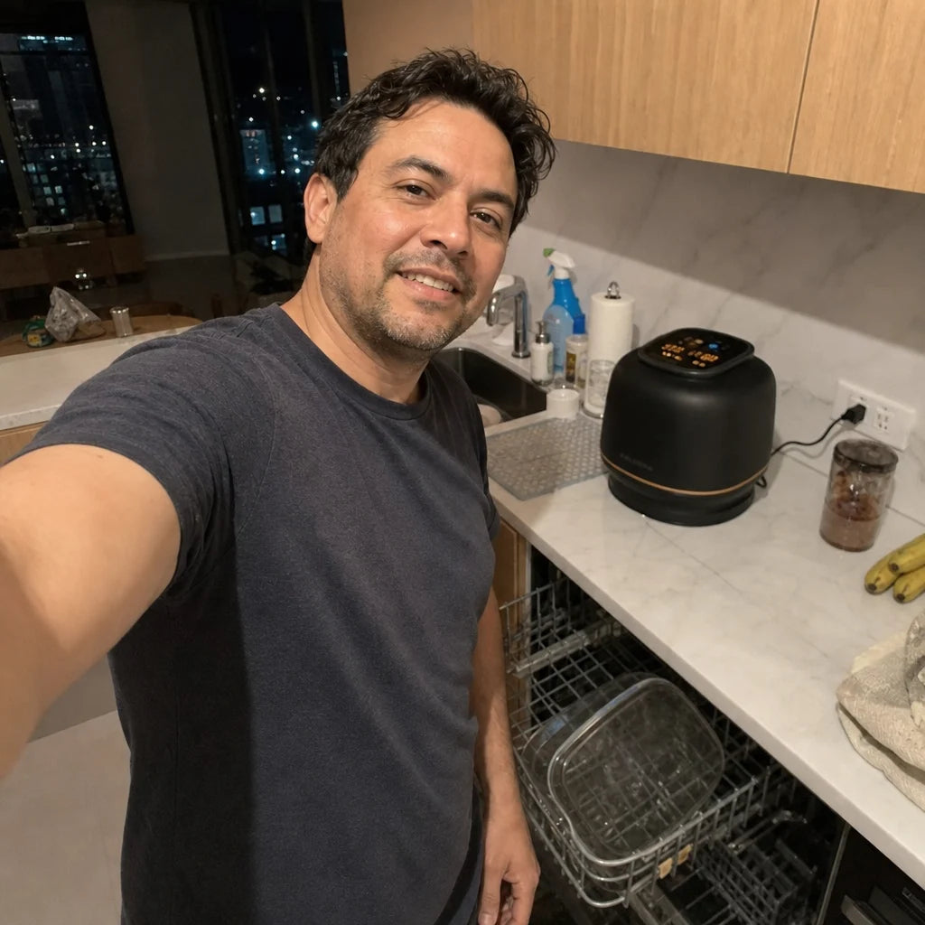 Tomas in his apartment kitchen next to the Kaldera Glass with the dishwasher open